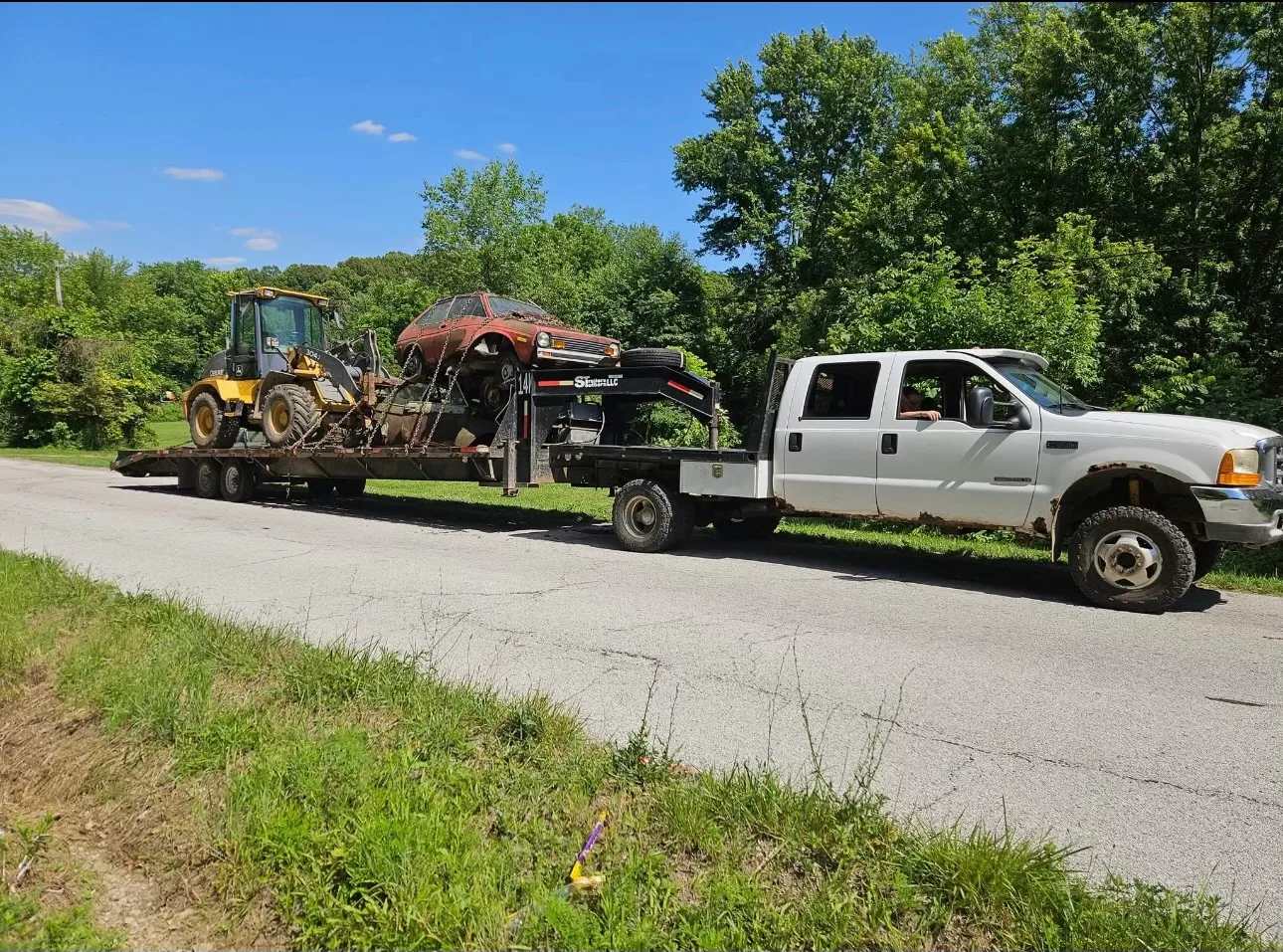Ohio Junk Cars white truck with junk car on trailer